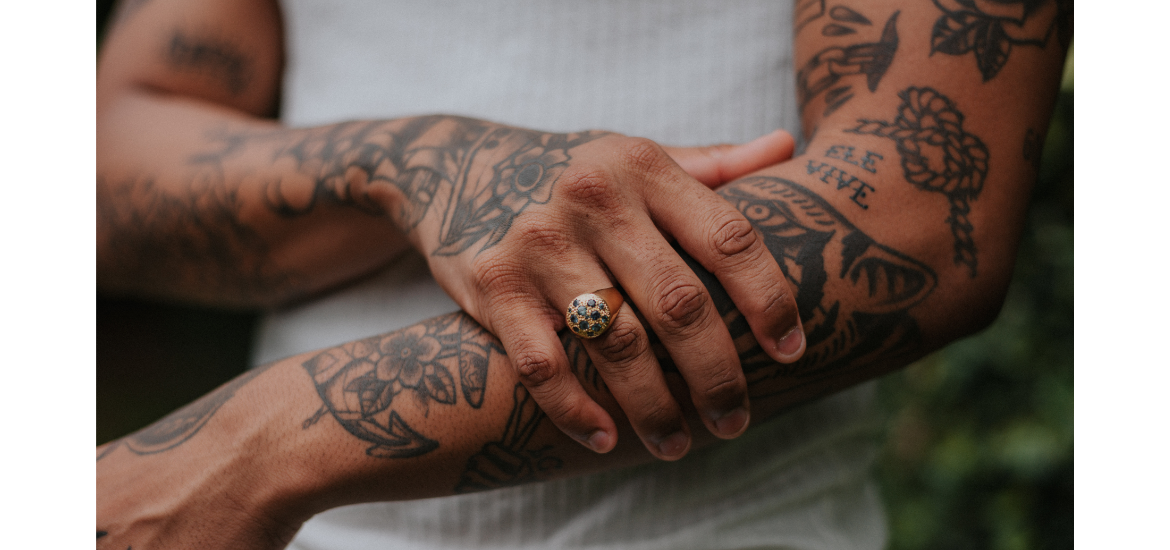 La imagen muestra un primer plano de los brazos de una persona con múltiples tatuajes.